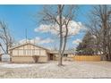 Ranch-style home with front yard, mature tree, and partial snow cover on a sunny day at 3596 E Fair Pl, Centennial, CO 80121