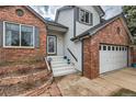 Inviting entryway with white stairs leading to the front door of a charming two-story home with brick and siding at 9821 Rock Dove Ln, Highlands Ranch, CO 80129