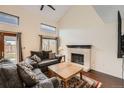 Cozy living room features a fireplace, hardwood floors, comfortable seating, and natural light from windows and doors at 9821 Rock Dove Ln, Highlands Ranch, CO 80129