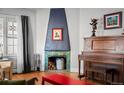 Stylish living room features a unique fireplace, hardwood floors, and a vintage piano at 1429 Hudson St, Denver, CO 80220