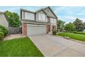Attractive two-story home boasts a well-kept lawn, brick details, and a spacious driveway at 20710 E Princeton Pl, Aurora, CO 80013
