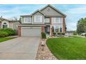 Inviting two-story home features a well-manicured lawn, brick accents, and a two-car garage at 20710 E Princeton Pl, Aurora, CO 80013
