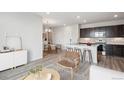 Open floor plan featuring a modern kitchen with dark cabinetry, stainless steel appliances, and barstool seating at 485 Interlocken Blvd # 201, Broomfield, CO 80021