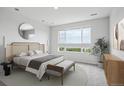 Serene main bedroom with a large window, decorative mirror, and contemporary furnishings at 485 Interlocken Blvd # 201, Broomfield, CO 80021