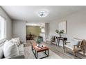 Inviting living room with stylish furniture, light gray walls, and seamless open-concept design leading to dining area at 9141 Gail Ct, Thornton, CO 80229