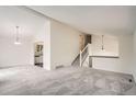 Spacious living room with vaulted ceilings, plush carpeting, and a view into the kitchen at 1800 Centaur Village Dr, Lafayette, CO 80026