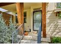 Cozy front porch with wood columns, modern railings and welcoming entrance door at 10671 E 28Th Ave, Denver, CO 80238