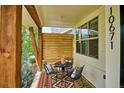 Inviting covered front porch seating area with wood accents and decor at 10671 E 28Th Ave, Denver, CO 80238