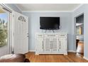 Comfortable living room with hardwood floors, a large entertainment center, and an open doorway at 1920 Ulster St, Denver, CO 80220