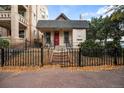 Charming home with red door and black wrought iron fence covered in fall leaves at 1516 Lafayette St, Denver, CO 80218