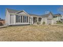 Single story ranch with gray siding, stone column accents, and attached two car garage at 21585 E Powers Cir, Centennial, CO 80015