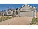 Single-story ranch home featuring a concrete driveway and attached two-car garage at 21585 E Powers Cir, Centennial, CO 80015