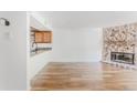 Living room with a stone fireplace and hardwood floors, complemented by an open kitchen at 2727 Folsom St # 210, Boulder, CO 80304