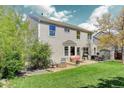 Spacious backyard with patio area, fire pit, lush lawn, and mature trees, ideal for outdoor enjoyment at 15432 Greenstone Cir, Parker, CO 80134