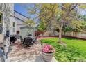 Serene backyard with mature tree, patio, lawn, and dining set, perfect for outdoor gatherings and enjoying nature at 15432 Greenstone Cir, Parker, CO 80134