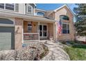 Inviting front porch with lovely accents and a view of the well-kept yard at 15432 Greenstone Cir, Parker, CO 80134