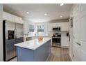 Modern kitchen featuring stainless steel appliances, a spacious island with white countertop, and white cabinetry at 15432 Greenstone Cir, Parker, CO 80134