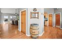 Inviting entryway featuring hardwood floors, decorative barrel, and archway to the kitchen at 43097 Taos Trl, Elizabeth, CO 80107