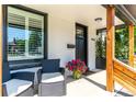 Inviting front porch featuring seating, a black door, and stylish accents at 4467 King St, Denver, CO 80211