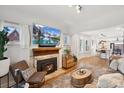 Cozy living room with a fireplace, neutral decor, and abundant natural light at 4467 King St, Denver, CO 80211