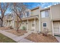 Tan colored townhome exterior with small front yard and walkway at 1818 S Quebec Way # 11-8, Denver, CO 80231