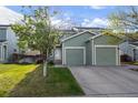 A charming two-story home with a well-maintained lawn, white door, and attached two-car garage at 747 Mockingbird St, Brighton, CO 80601