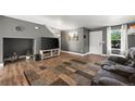 A cozy living room with hardwood floors, gray walls, modern decor, and natural light from the front door at 747 Mockingbird St, Brighton, CO 80601