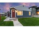 Cozy single-story home featuring blue siding, a red front door, and a well-maintained lawn for a welcoming appearance at 1414 W Nevada Pl, Denver, CO 80223