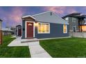 Charming home with a red door, lush lawn, and freshly painted exterior at dusk at 1414 W Nevada Pl, Denver, CO 80223