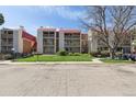 Exterior view of the condominium complex showing lawn and trees at 14700 E Kentucky Dr # 524, Aurora, CO 80012