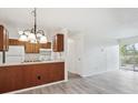 Bright kitchen with white appliances, wood cabinets, and breakfast bar open to the living area at 14700 E Kentucky Dr # 524, Aurora, CO 80012