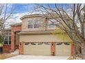 Beautiful two-story home featuring a brick facade and a three-car garage with decorative doors at 9743 Las Colinas Dr, Lone Tree, CO 80124