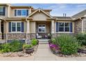 Charming home featuring a welcoming front porch with stone accents and beautiful landscaping at 12919 W Burgundy Dr, Littleton, CO 80127