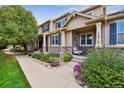 Inviting home with a well-maintained lawn, front porch, and stone detailing at 12919 W Burgundy Dr, Littleton, CO 80127