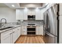 Modern kitchen showcasing stainless steel appliances, white cabinets, and granite countertops at 12919 W Burgundy Dr, Littleton, CO 80127