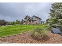 A stunning exterior view showcasing the lush landscaping and spacious lawn surrounding the home at 15102 Prairie Pl, Broomfield, CO 80023