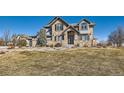 Inviting stone and stucco two-story home featuring well-manicured lawn and tasteful exterior finishes at 15102 Prairie Pl, Broomfield, CO 80023