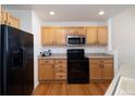 Efficient kitchen design with wooden cabinets, sleek black appliances, and functional layout at 23625 E Kettle Pl, Aurora, CO 80016