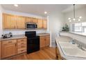 Well-equipped kitchen featuring stainless steel appliances, wood cabinetry, and hardwood flooring at 23625 E Kettle Pl, Aurora, CO 80016