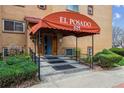 Apartment building entrance under red awning, with trimmed landscaping and steps at 625 N Pennsylvania St # 208, Denver, CO 80203