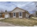 Charming home with a brick facade, vinyl siding, solar panels, attached garage and a well-kept front lawn at 427 Hickory St, Broomfield, CO 80020