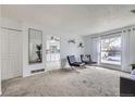 Bright and airy living room with carpet, white walls, and view to the kitchen at 427 Hickory St, Broomfield, CO 80020