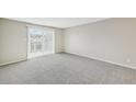 Living room featuring gray carpet and sliding door to a patio at 7395 E Quincy Ave # 207, Denver, CO 80237