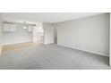 Spacious living room with carpet flooring adjacent to the kitchen at 7395 E Quincy Ave # 207, Denver, CO 80237