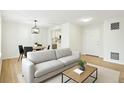 Comfortable living room with hardwood floors next to dining area and kitchen at 1383 W 88Th Ave # 307, Thornton, CO 80260
