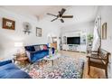 Cozy living room featuring hardwood floors, colorful rug, ceiling fan, and natural light at 3106 N Franklin St, Denver, CO 80205