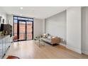 Sun-filled living room with hardwood floors, comfortable seating, and a large window showing the cityscape at 1901 Wazee St # 305, Denver, CO 80202