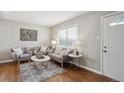 Cozy living room with hardwood floors, neutral paint, stylish furniture and patterned rug at 1760 S Yuma St, Denver, CO 80223