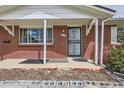 Close-up of front porch with brick facade and black security door and concrete blocks at 1325 Elder St, Denver, CO 80221