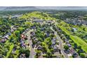 A sprawling neighborhood is showcased in an aerial view surrounded by lush greenery at 11932 W 56Th Cir, Arvada, CO 80002